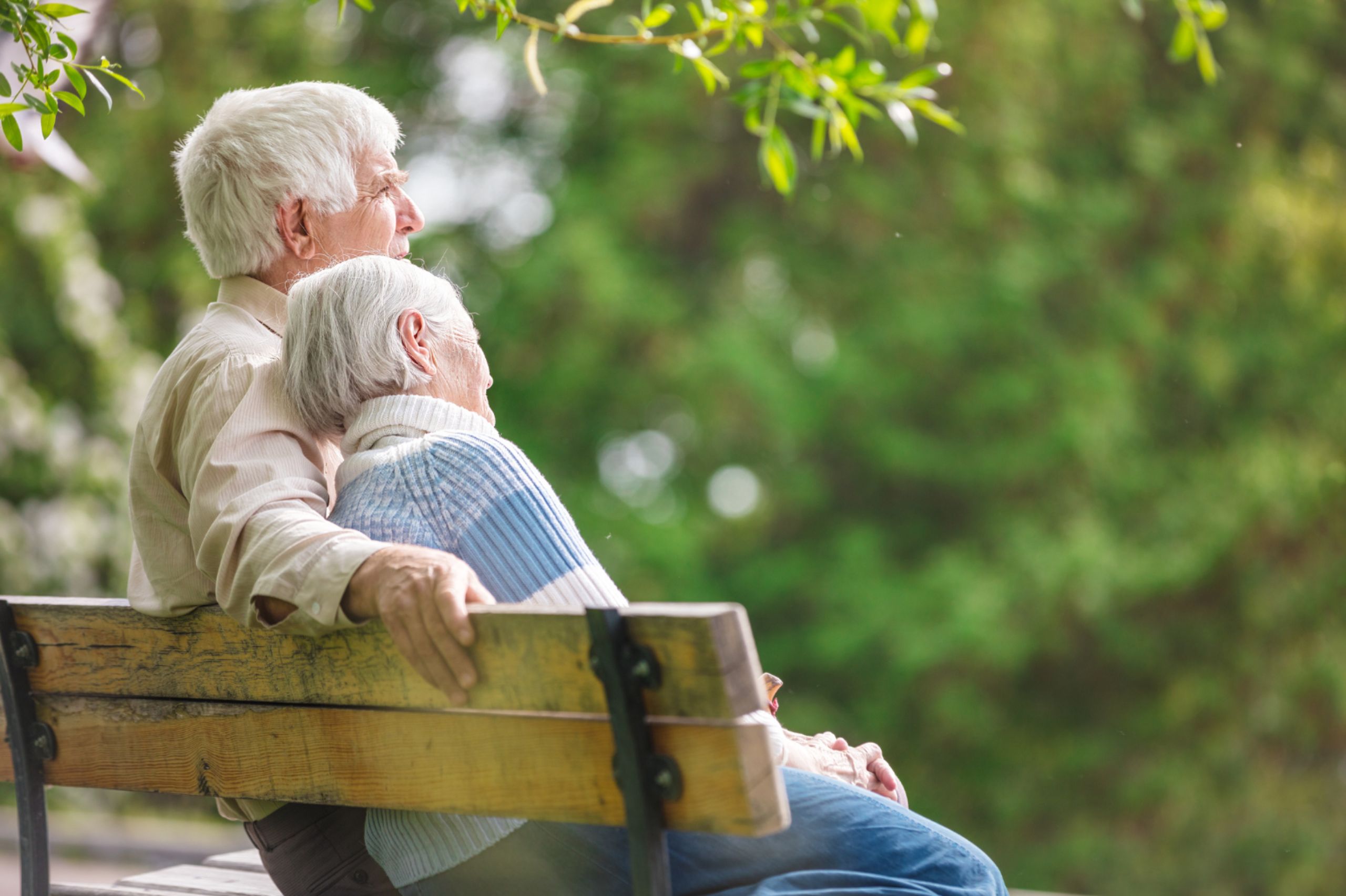 insured-elderly-couple-sit-happily-on-bench